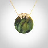 This piece is a medium sized cupped disc pendant. It was carved for us by Ric Moor from a lovely deep and milky green piece of New Zealand flower jade. It is suspended on a beige coloured braided cord that is length adjustable.